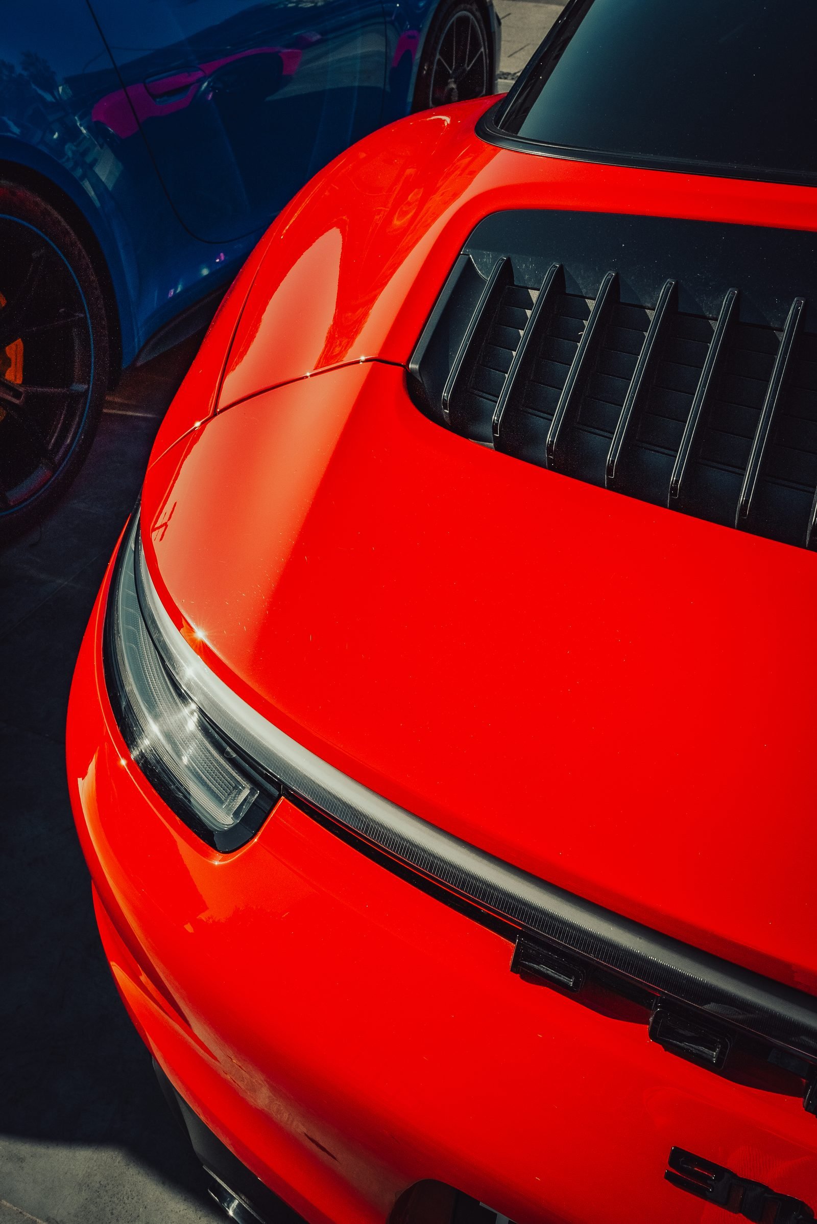 Red sports car rear with black louvres and twin exhaust exits