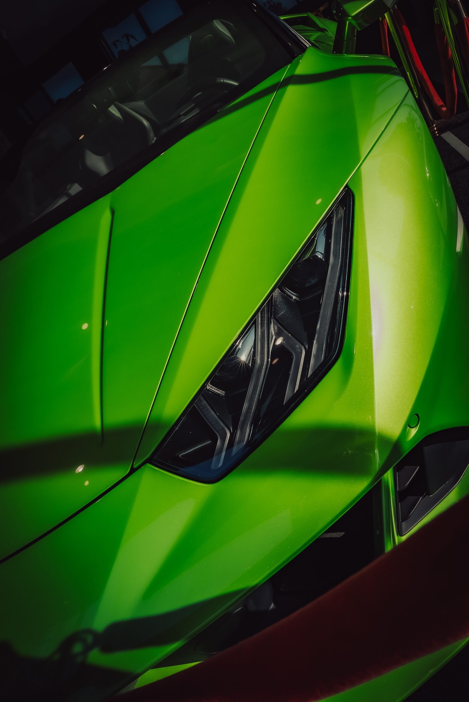 Acid green nose of a supercar with a sharp black headlamp